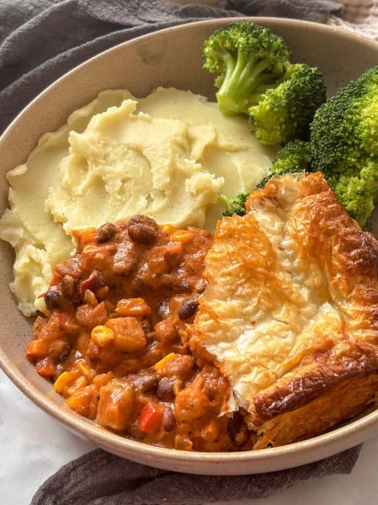 a plate of chilli bean pie and mashed potato and broccoli