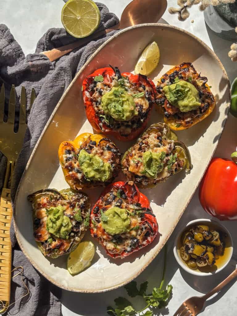 Mexican stuffed peppers topped with guacamole and cilantro