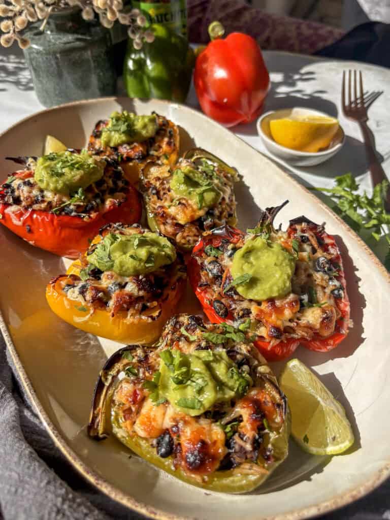 mexican stuffed peppers on a serving plate with guacamole