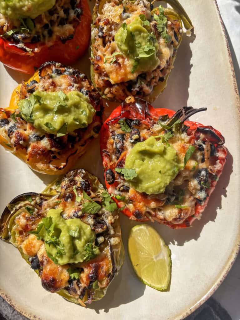 Mexican stuffed peppers topped with guacamole and cilantro