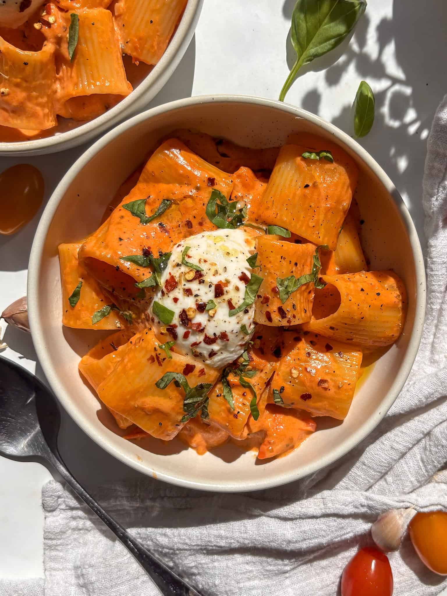 creamy tomato pasta sauce tossed through short rigatoni, topped with a mini burrata ball, red chili flakes, fresh basil, and a drizzle of olive oil