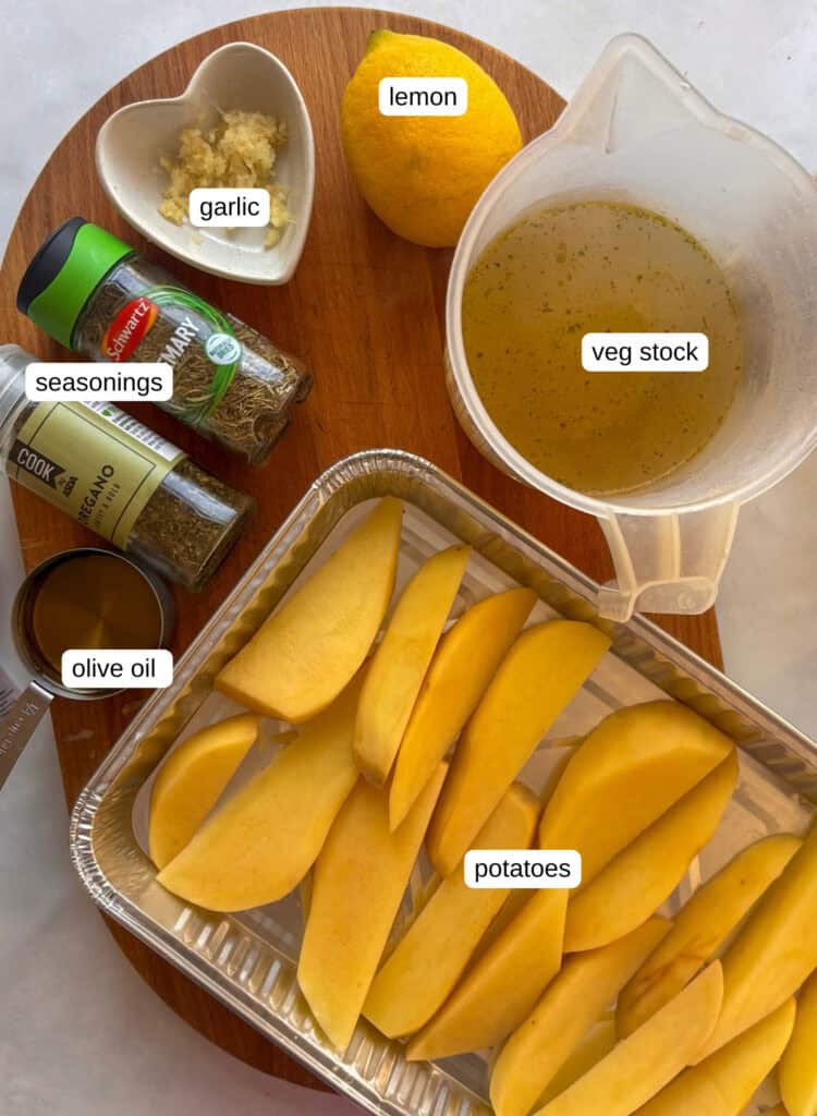 ingredients shot for greek potatoes: potatoes, stock, lemon, garlic, oregano, rosemary, olive oil