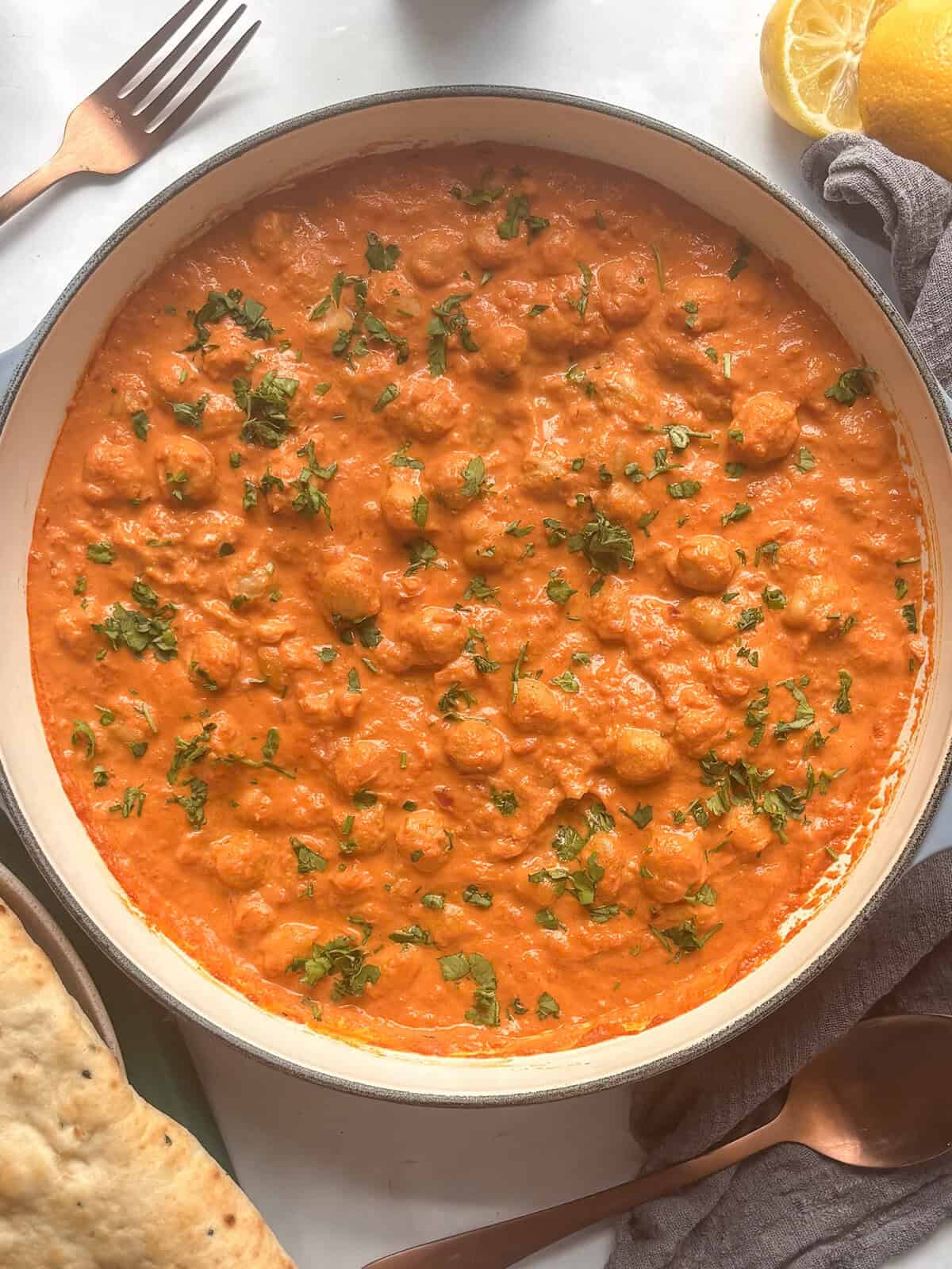 a pan of Indian butter chickpea curry topped with fresh cilantro