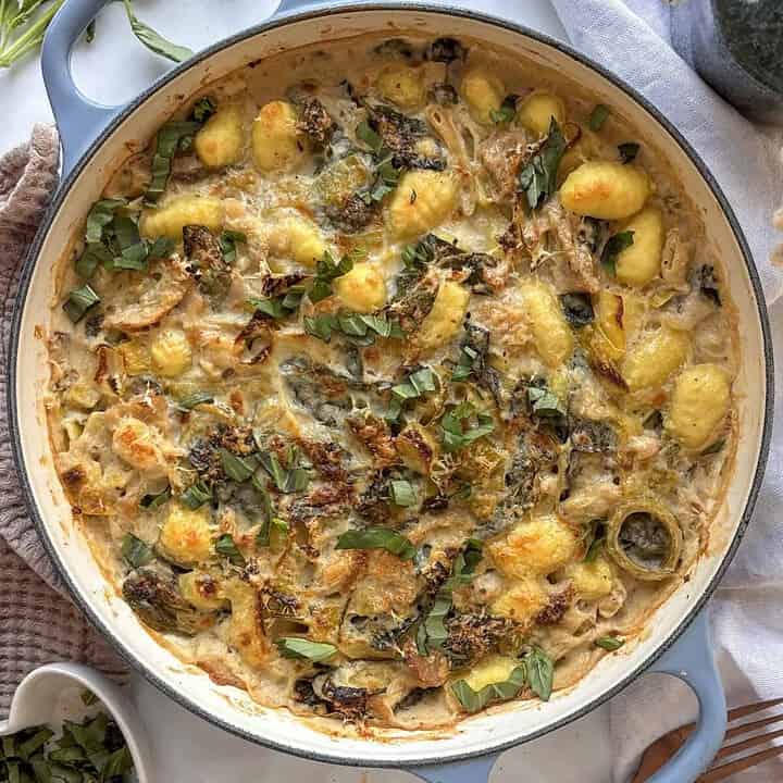a casserole pan of leek and gnocchi bake topped with crispy Pecorino cheese