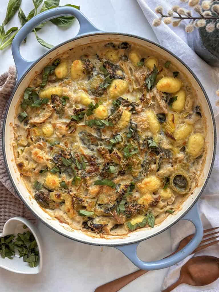 a casserole pan of leek and gnocchi bake topped with crispy Pecorino cheese