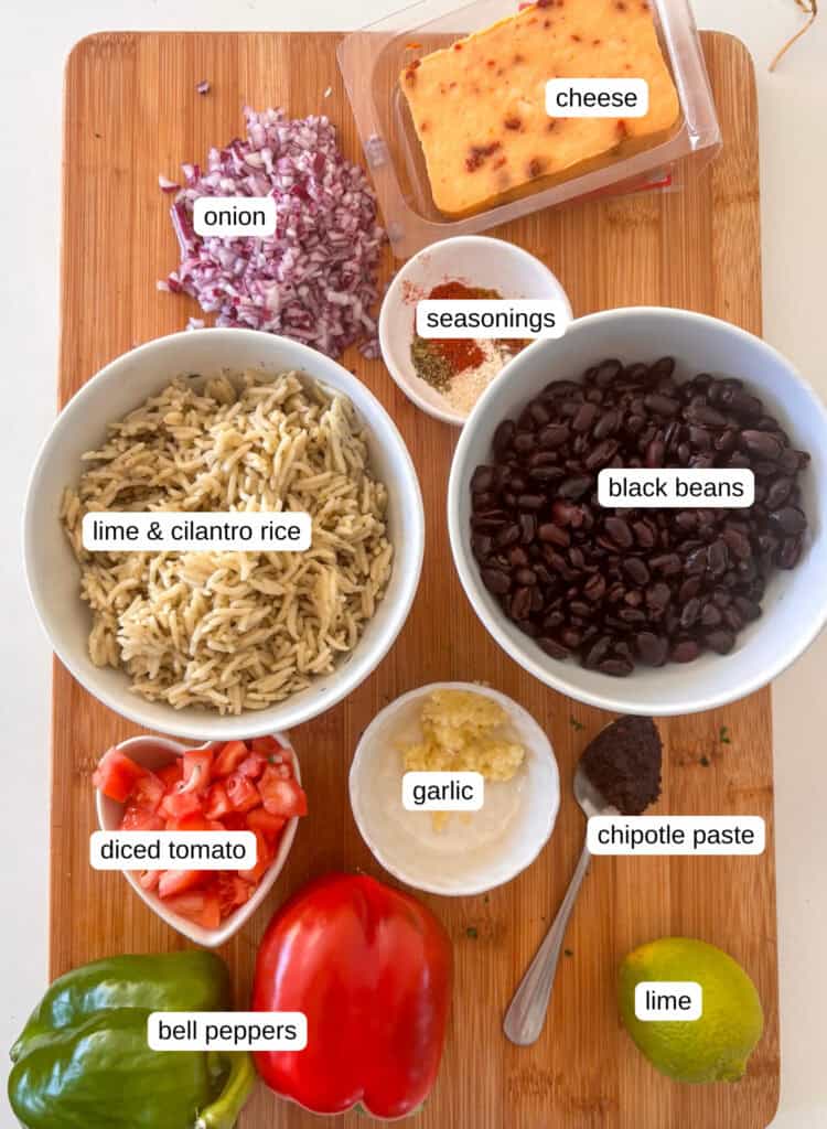 mexican stuffed peppers ingredients list: cheese, red onion, seasonings, lime and cilantro rice, black beans, diced tomatoes, garlic, chipotle paste, bell peppers
