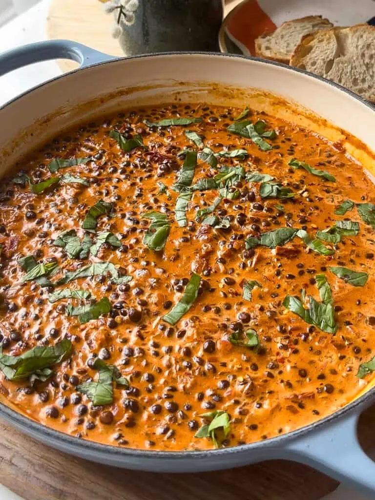 a casserole pan of marry me lentils - in a creamy sun-dried tomato sauce with fresh basil and lemon juice