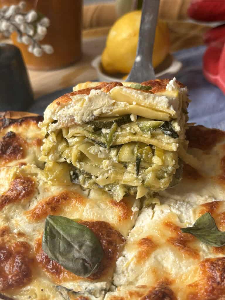 a sliceof the green lasagna with layers of zucchini, leeks, lasagna sheets, and ricotta sauce
