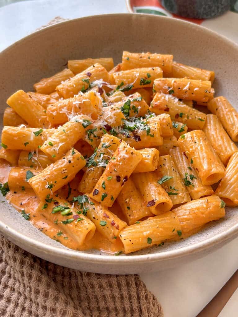 one bowl creamy tomato pasta with mascarpone cheese, topped with parsley and parmesan