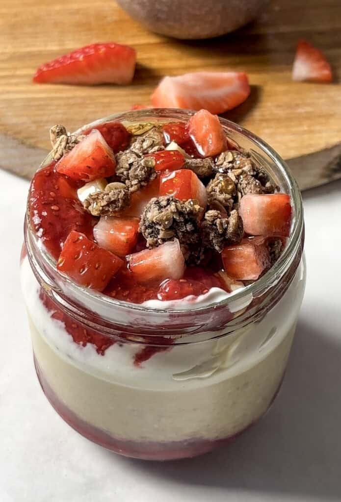 strawberry overnight oats topped with diced strawberries, granola, and a homemade chia strawberry jam