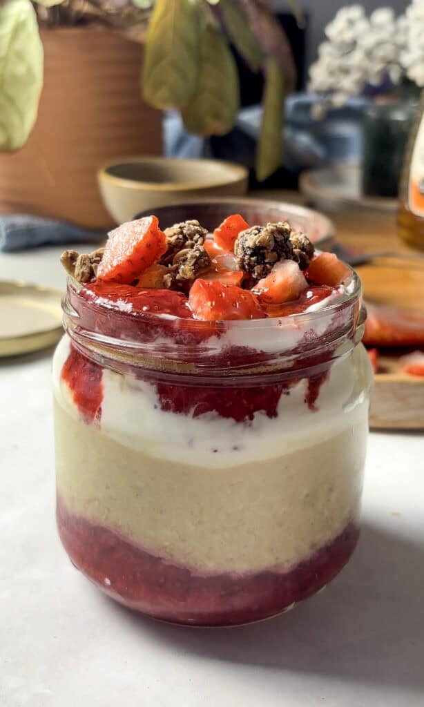 strawberry overnight oats topped with diced strawberries, granola, and a homemade chia strawberry jam