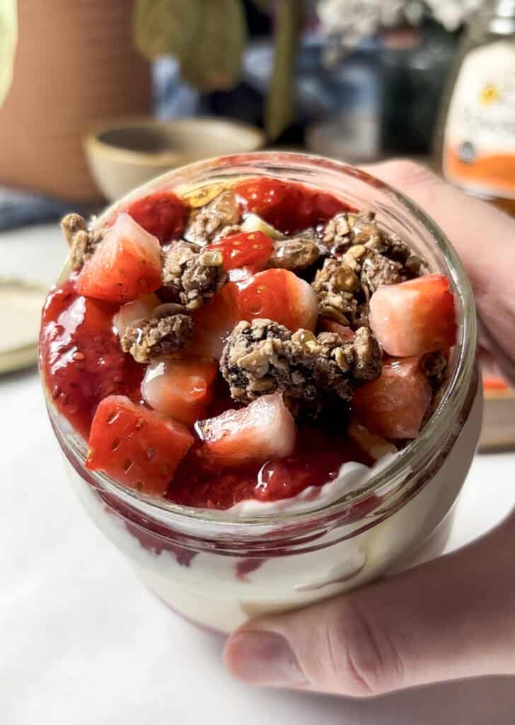 strawberry overnight oats topped with diced strawberries, granola, and a homemade chia strawberry jam