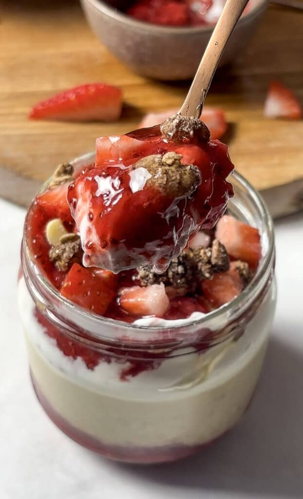 strawberry overnight oats topped with diced strawberries, granola, and a homemade chia strawberry jam