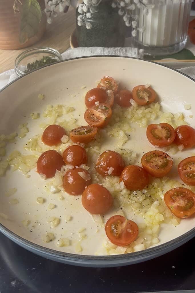 halved cherry tomatoes added to the pan with the diced onion