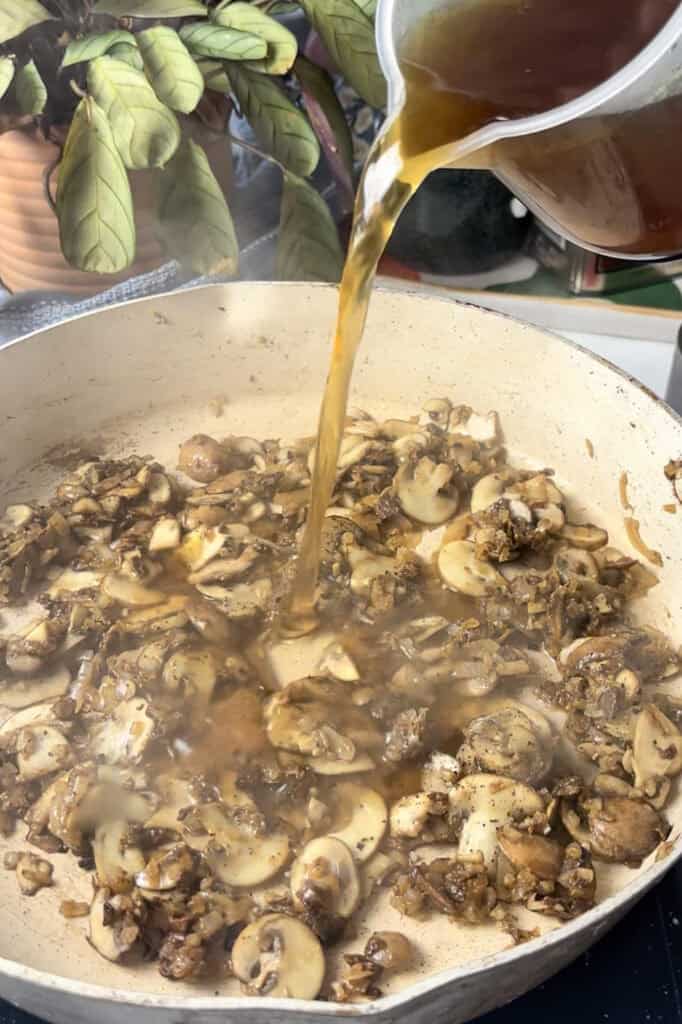 mushroom stock is poured into the pan to create the sauce
