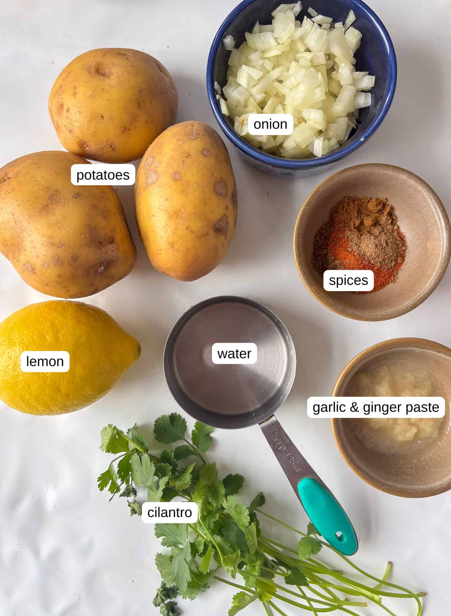 ingredients list for curried potatoes: potatoes, spices, onion, garlic and ginger paste, water, lemon juice and fresh cilantro