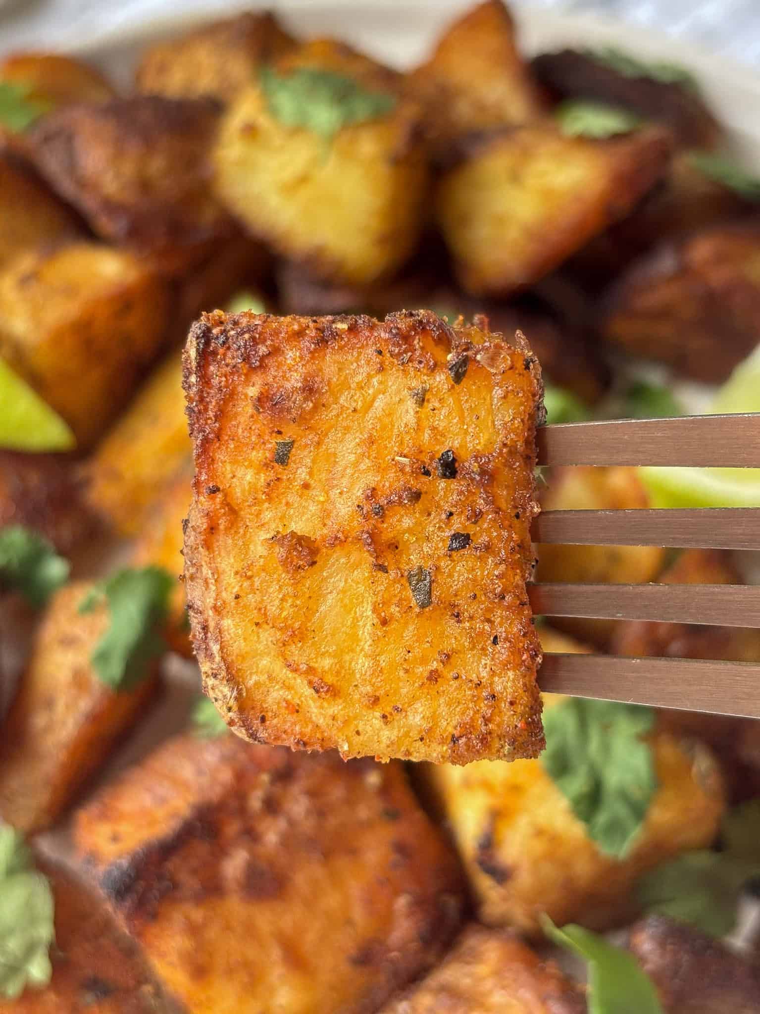 a close up photo of a crispy Mexican potato speared by a fork