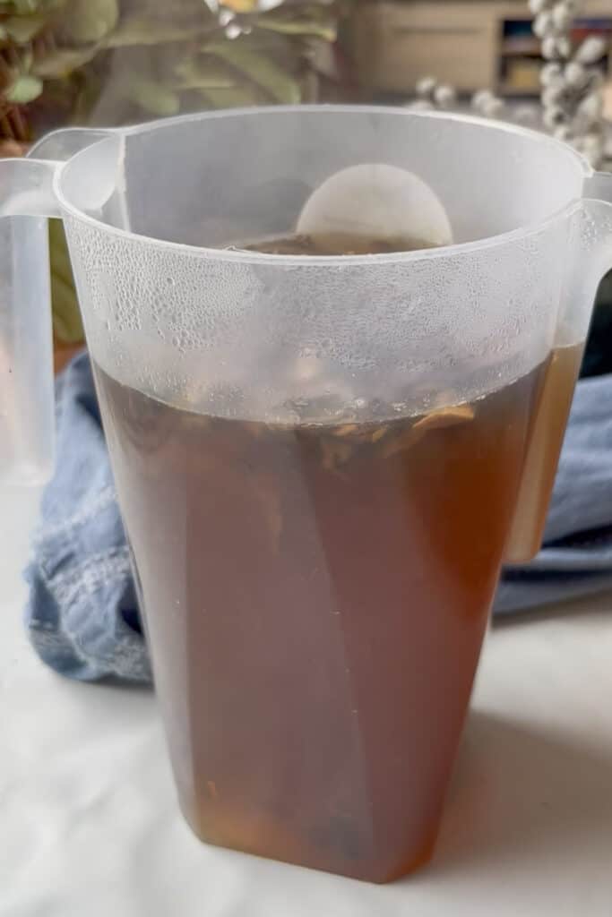 dried porcini mushrooms and a vegetable stock cube are added to a jug with boiling water so the mushrooms can steep in the stock