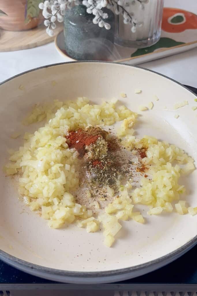 Mexican spices (paprika, oregano, chili powder, cumin) added to the pan with the cooked onions for the base of Spanish rice and beans