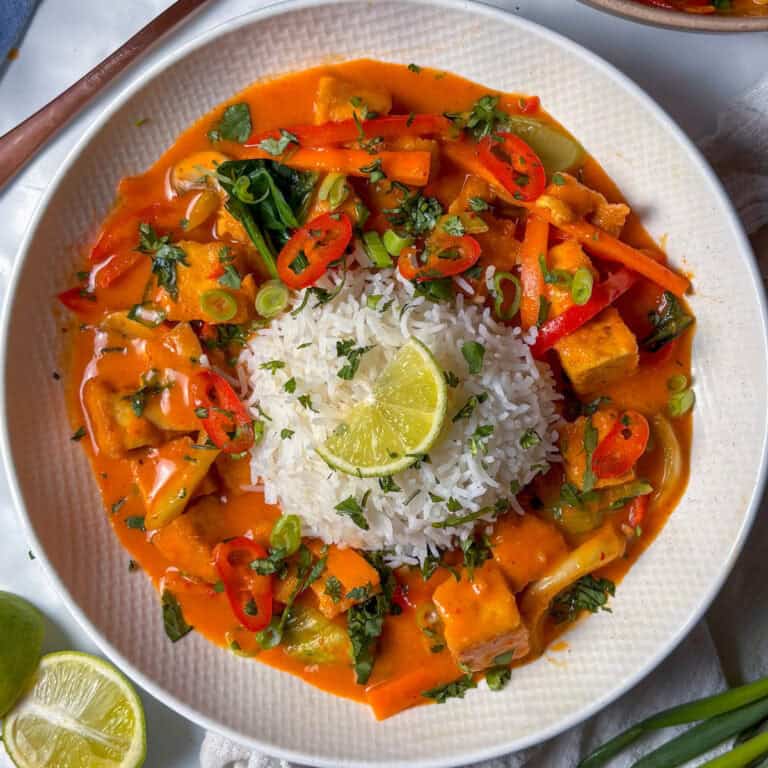 thai red curry with veggies and crispy tofu, served with rice, coriander, and lime