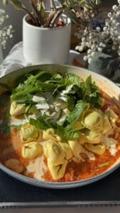 the Marry Me sauce with fresh spinach and ricotta tortellini, cream, and diced spinach added to the pan