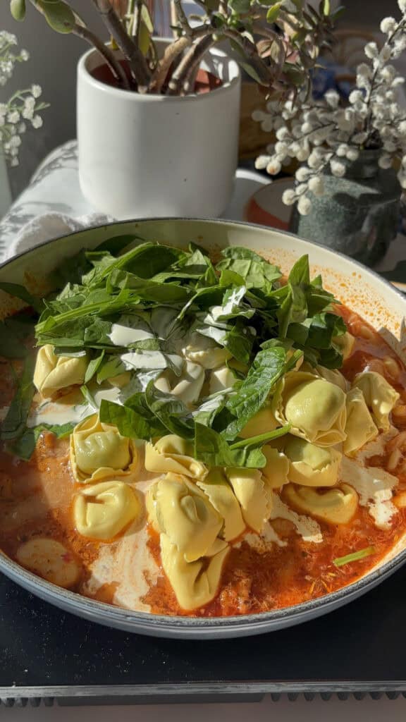 the Marry Me sauce with fresh spinach and ricotta tortellini, cream, and diced spinach added to the pan
