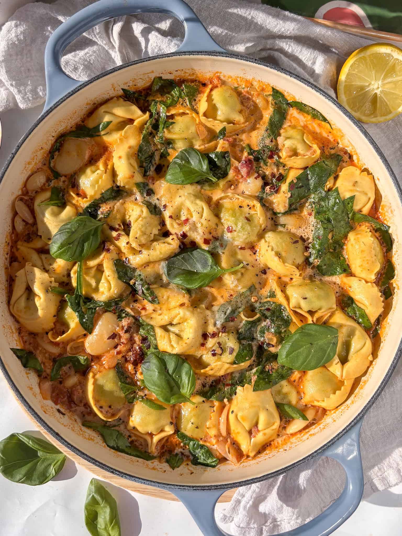 a finished photo of Marry Me tortellini nestled in a creamy sun-dried tomato topped with fresh basil