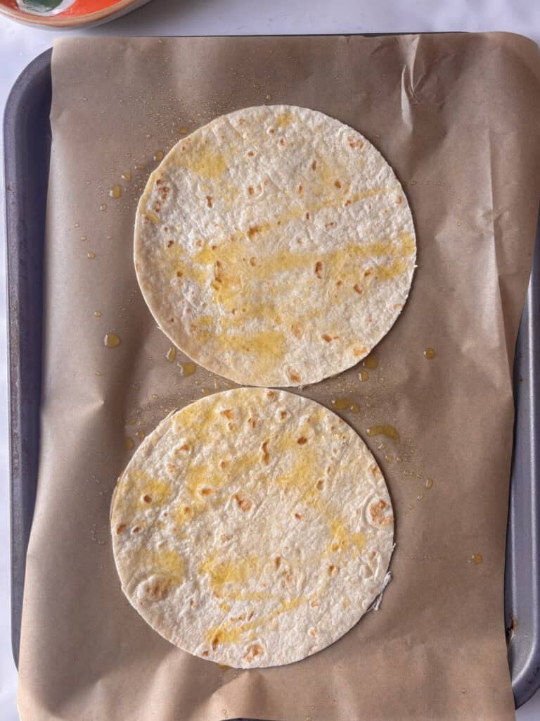 olive oil sprayed on mini tortilla wraps on a baking tray