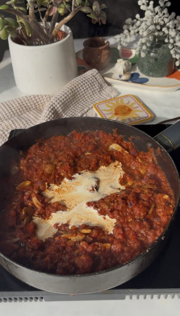 cream is added to the tomato sauce in a saucepan