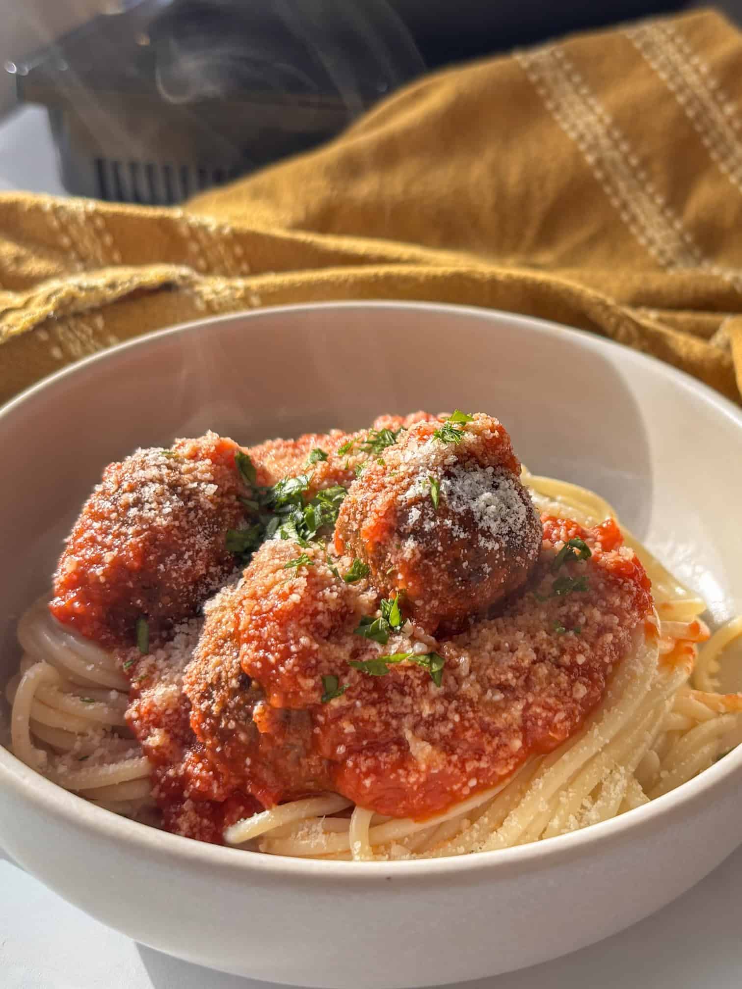 a bowl of lentil meatballs in a tomato sauce over spaghetti