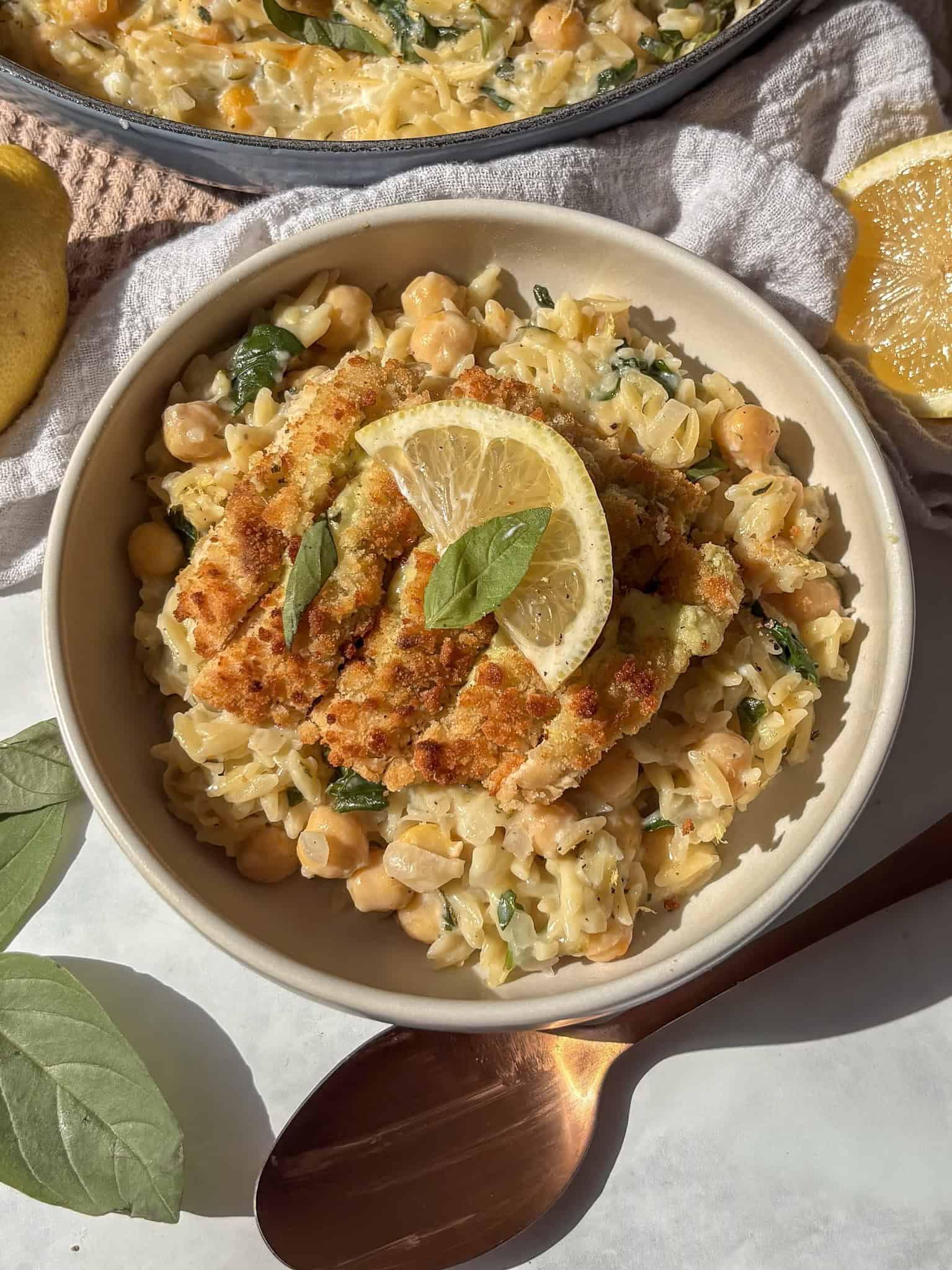 lemon orzo in a bowl, topped with a vegetarian chicken escalope