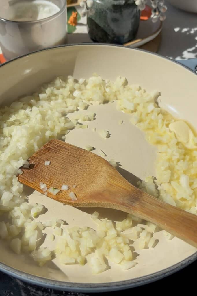 diced onion and garlic being sauted in butter