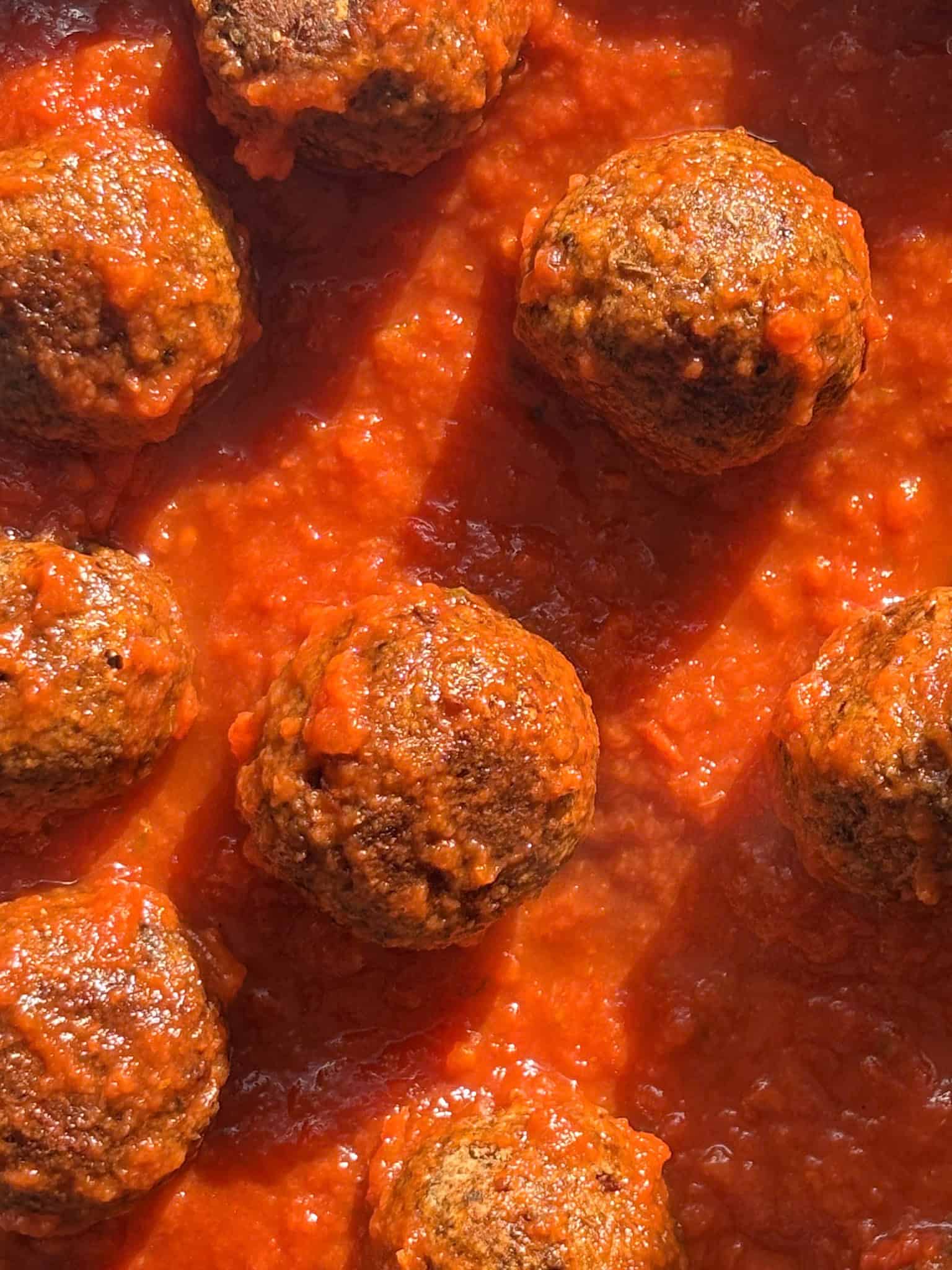 lentil meatballs cooking in a tomato sauce