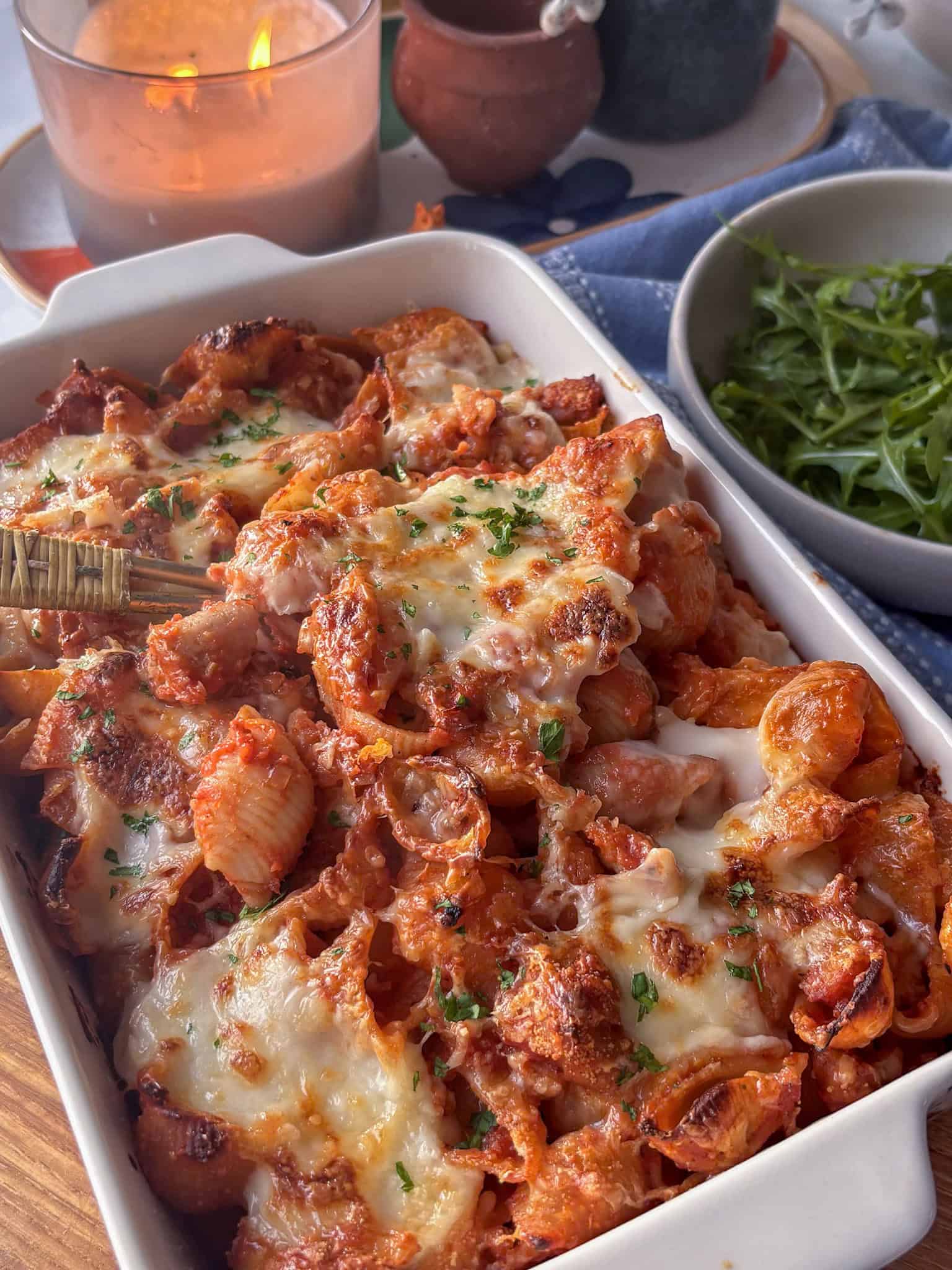 creamy sausage pasta bake in a casserole dish with cheesy topping