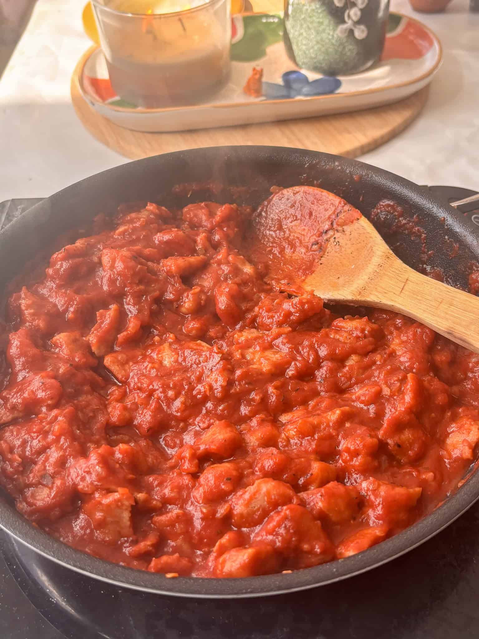 a tomato ragu with crumbled sausages in a saucepan