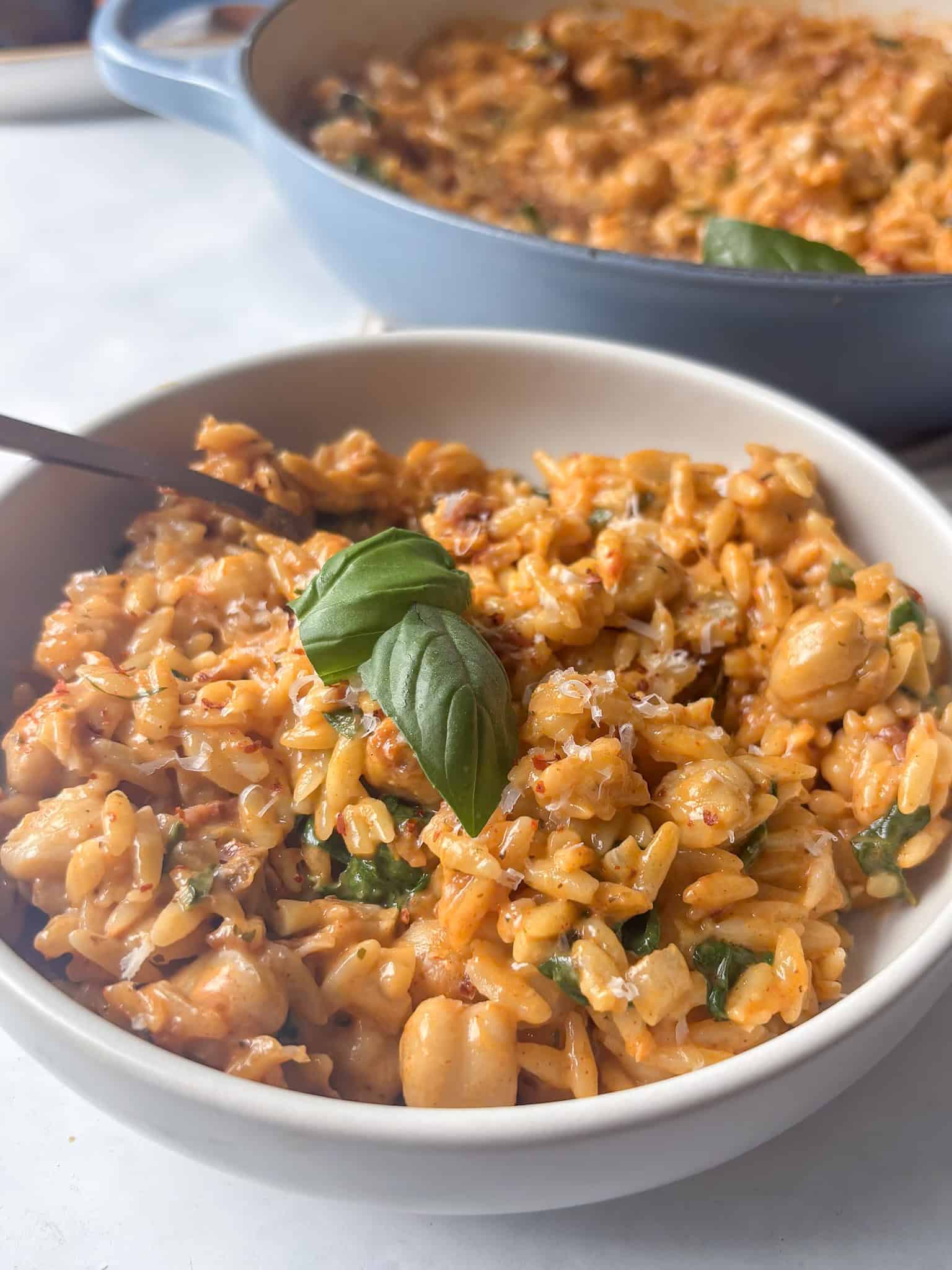 bowl of creamy marry me orzo topped with fresh basil