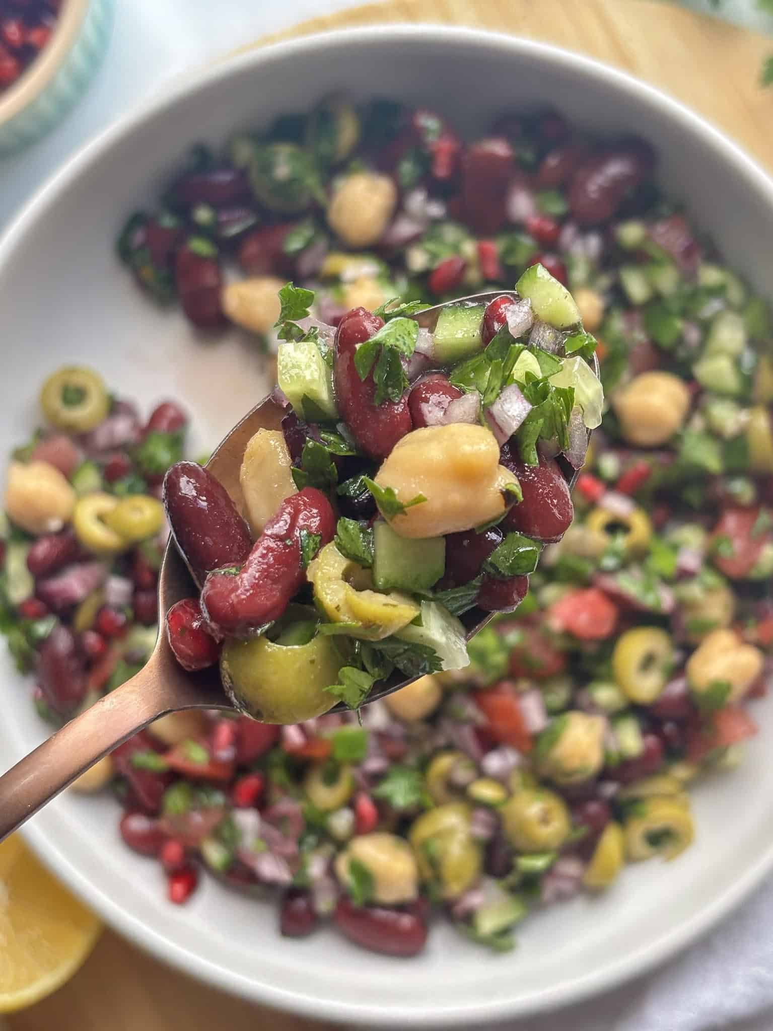 colorful mediterranean bean salad with chickpeas, kidney beans, and fresh salad vegetables