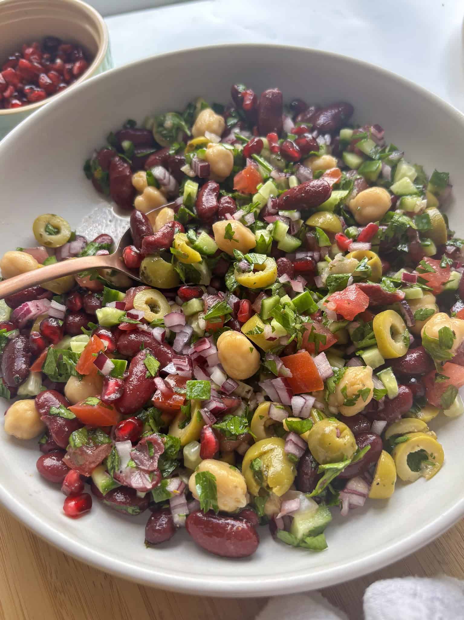 colorful mediterranean bean salad with chickpeas, kidney beans, and fresh salad vegetables