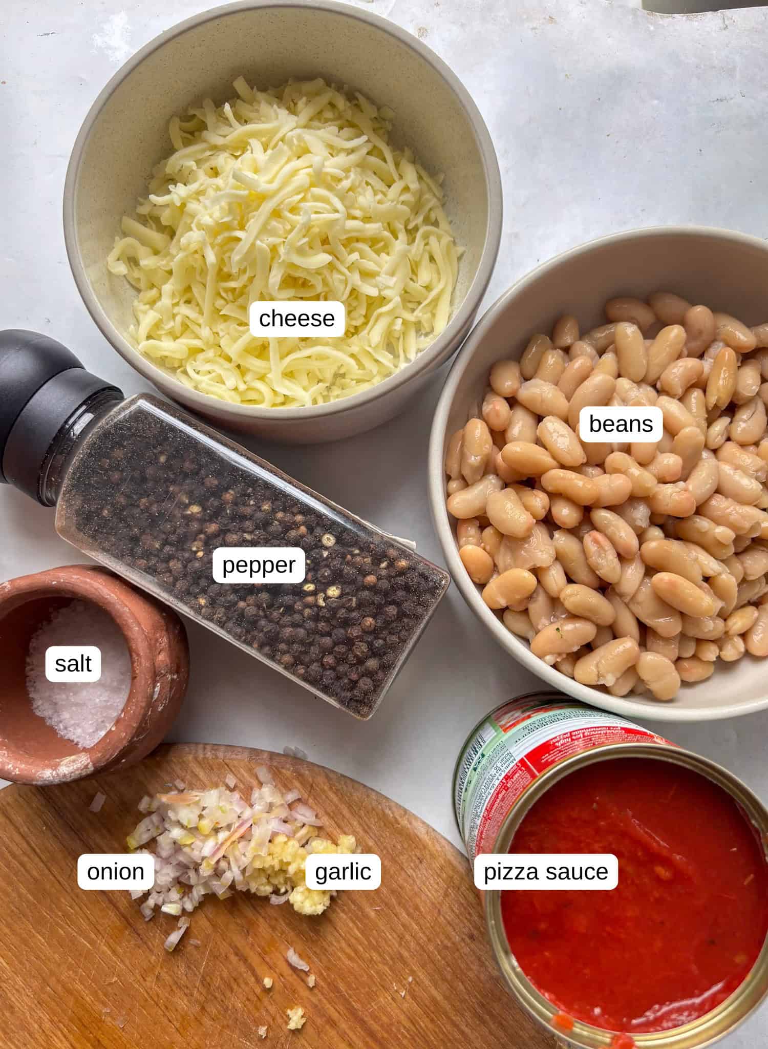 ingredients needed for pizza beans: white beans, mozzarella cheese, salt and pepper, pizza sauce, olive oil, onion, garlic