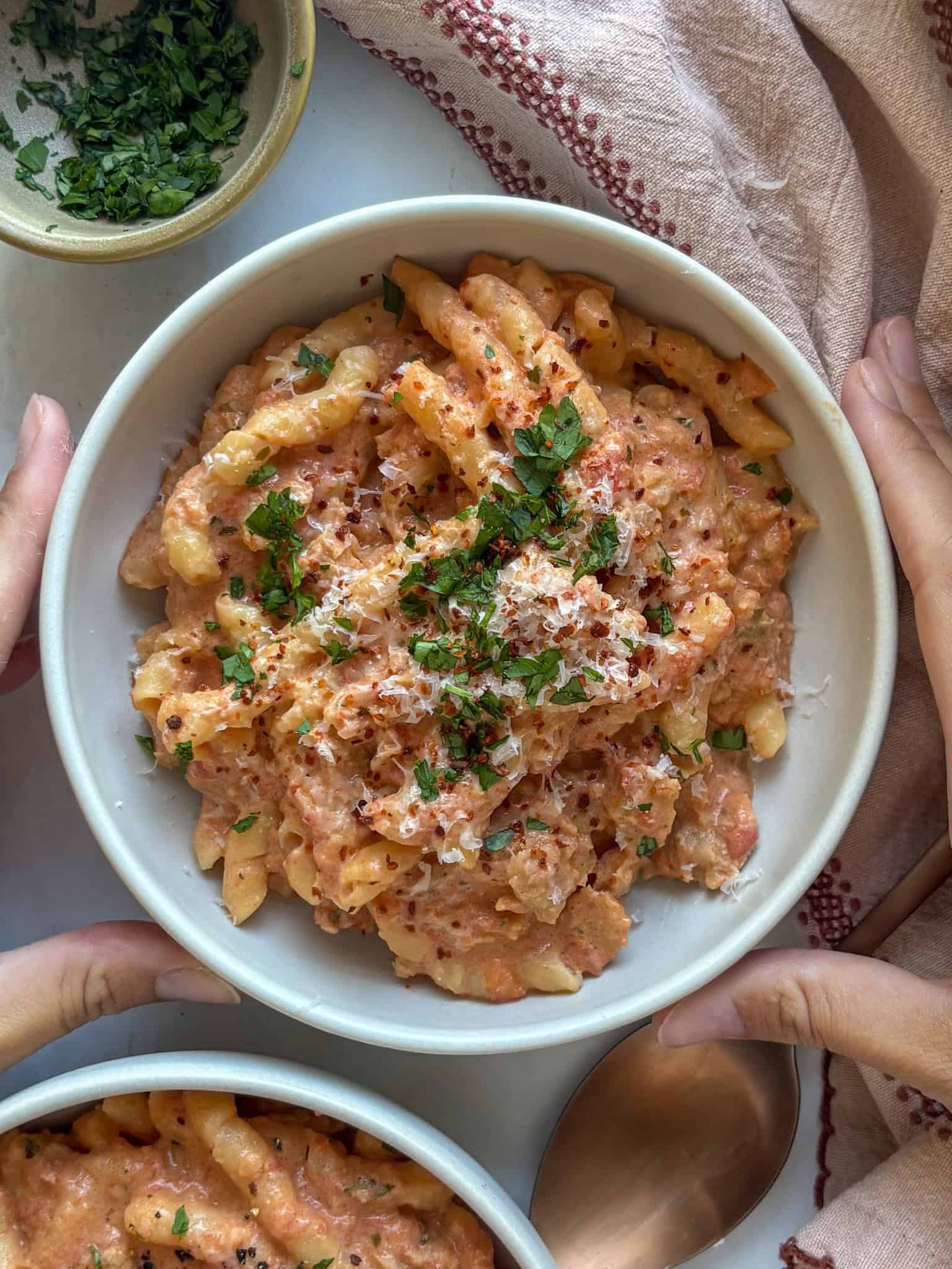 a bowl of creamy Boursin cheese pasta made with tomatoes, topped with fresh herbs and chili flakes