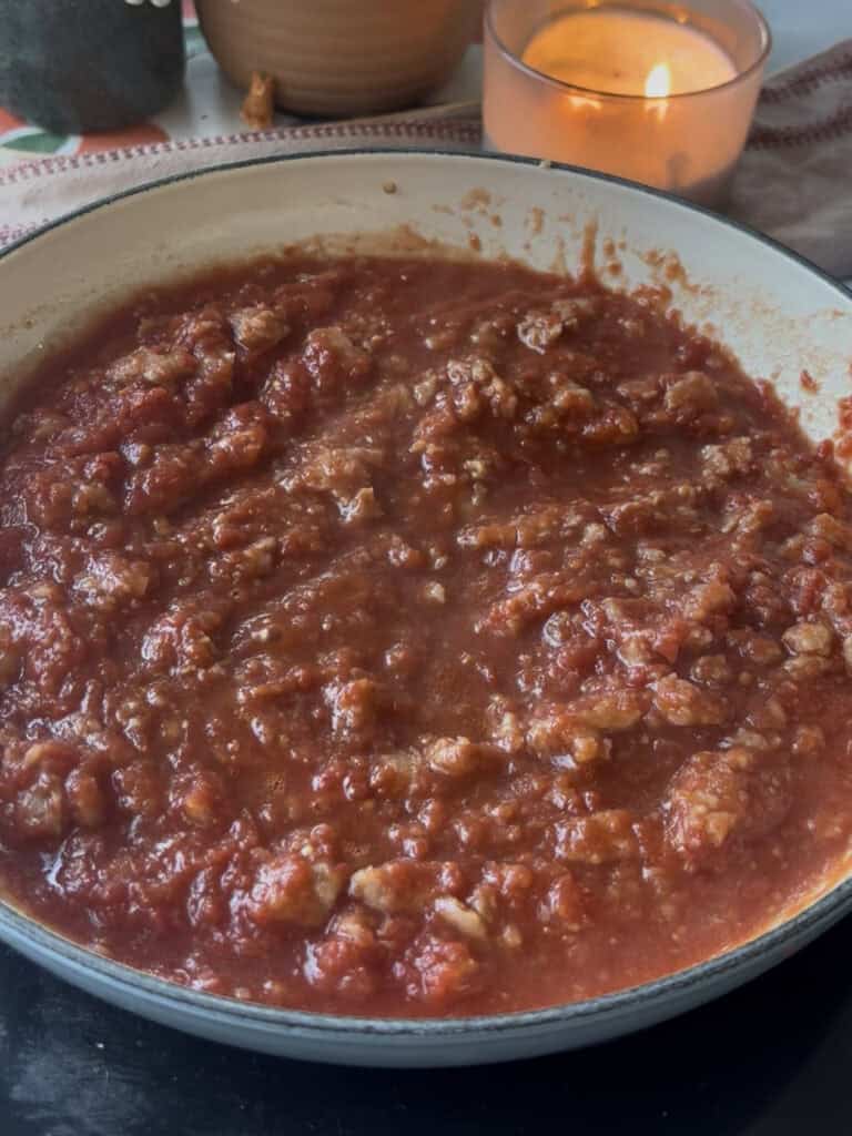 the crumbled sausages with chopped tomatoes and a dash of water added to the pan