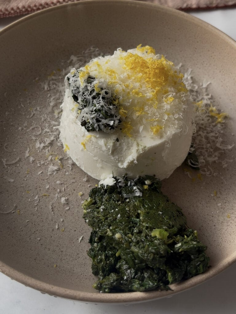 the spinach and ricotta ingredients added to a bowl before mixing