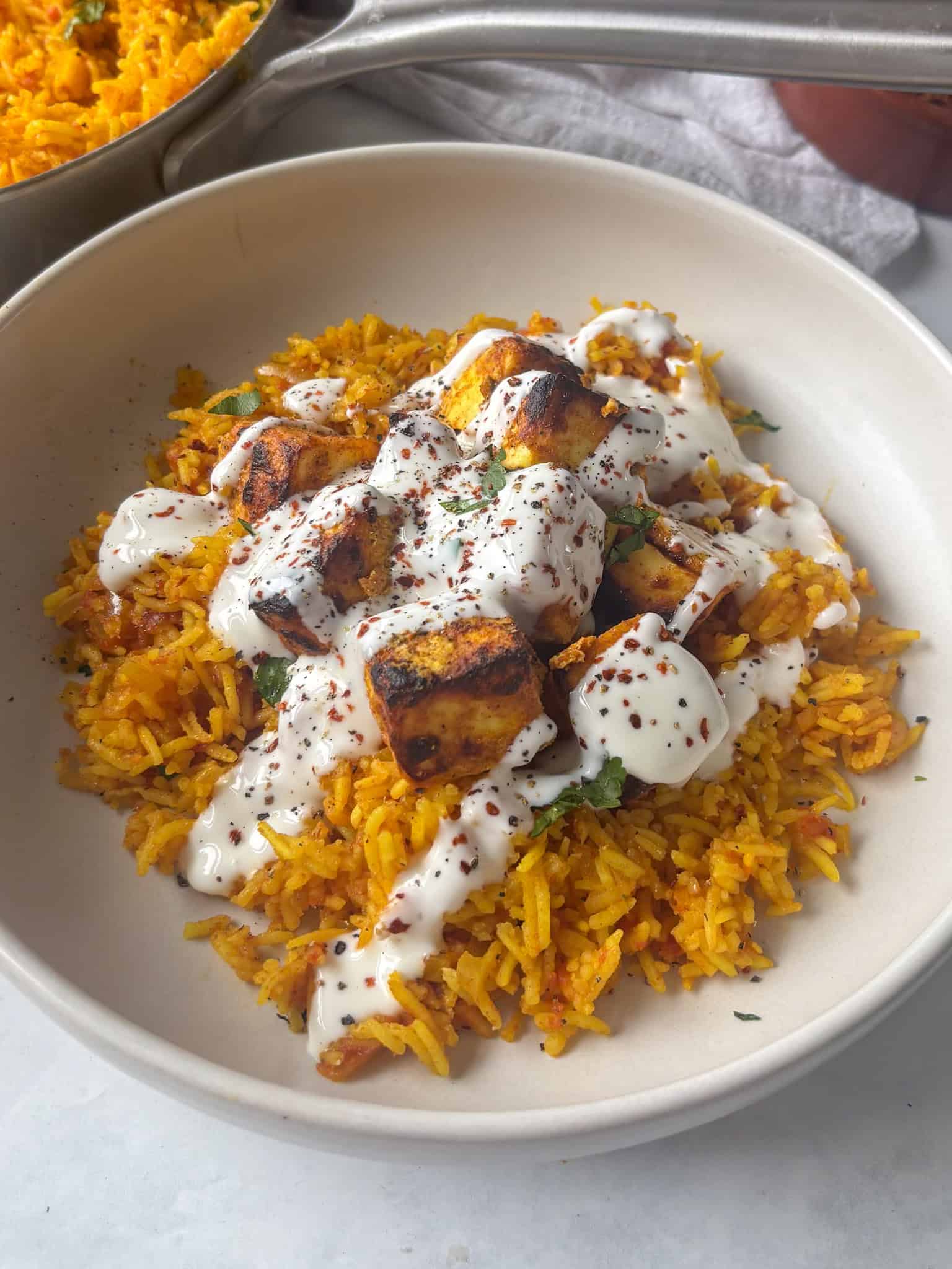 crispy peri peri paneer on top of spicy rice with garlic mayo yoghurt