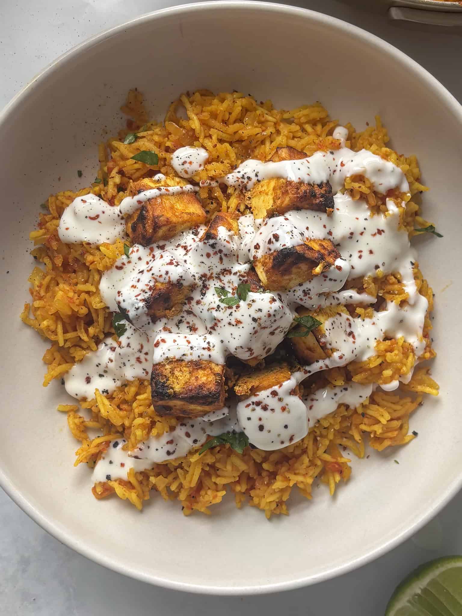 crispy peri peri paneer on top of spicy rice with garlic mayo yoghurt