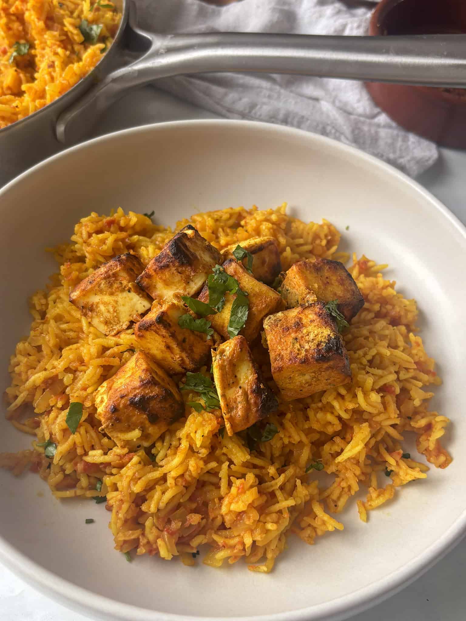 crispy peri peri paneer on top of spicy rice with garlic mayo yoghurt