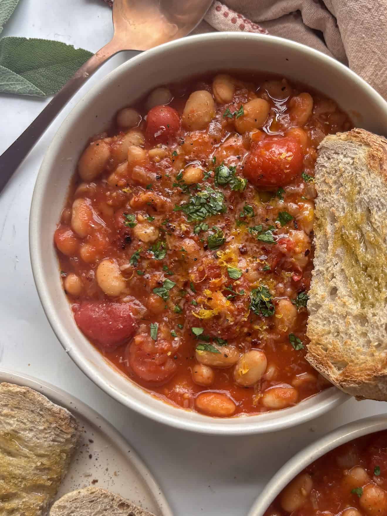 white bean stew in a bowl with a slice of sourdough toast