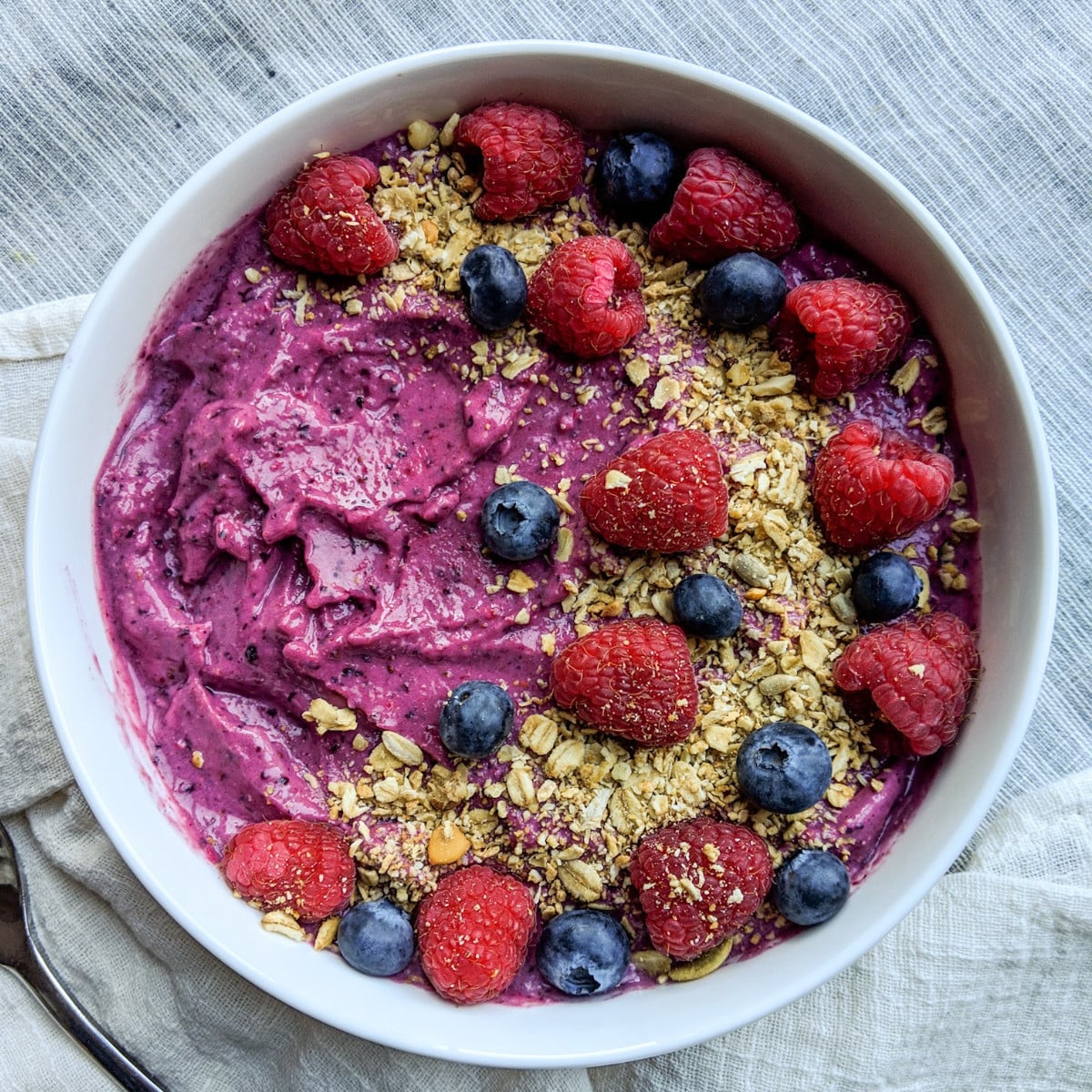 frozen fruit smoothie bowl topped with fresh fruit and granola
